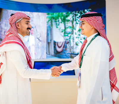 Two professionals shaking hands at Global Infrastructure Expo