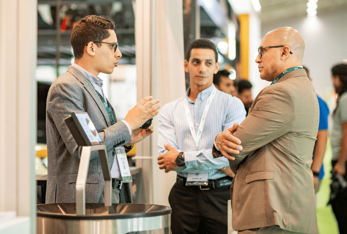 http://Three%20business%20professionals%20in%20discussion%20at%20an%20exhibition%20stand%20during%20an%20industry%20trade%20show
